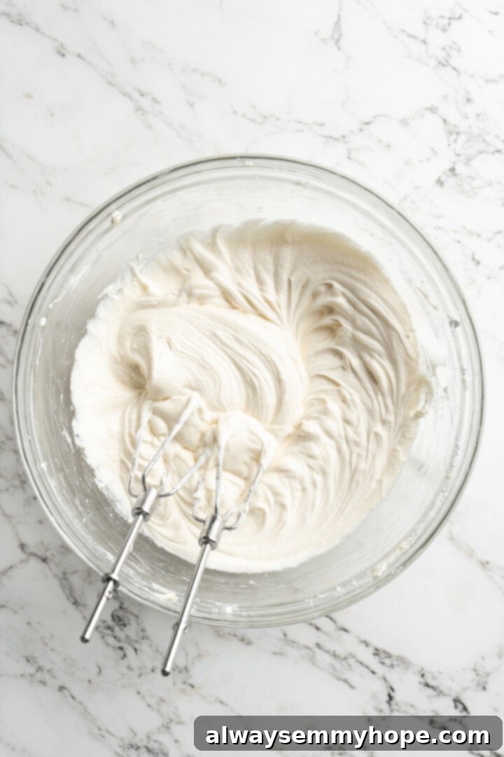 Moist, rich red velvet brownies are perfect for a special occasion or anytime you’re craving a decadent dessert. With cream cheese frosting! Overhead view of perfectly whipped vegan cream cheese frosting in a mixing bowl with electric beaters, showing its smooth, fluffy texture.