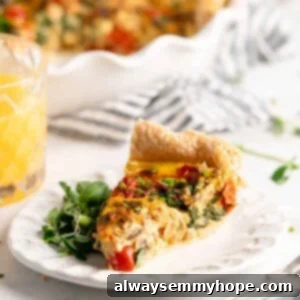 Slice of quiche on plate with greens, with glass of orange juice in background