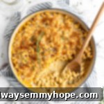 Baked vegan mac and cheese in skillet with wooden spoon