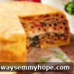 Timpano on cutting board with slices removed to show layers inside