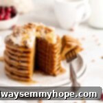 Stack of gingerbread pancakes topped with coconut whipped cream and maple syrup