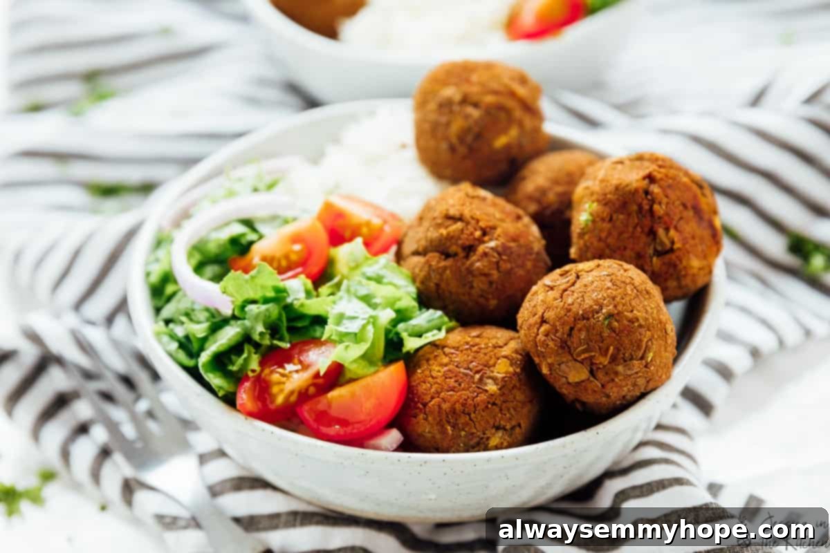 Close-up of baked lentil balls served in a bowl with fluffy zesty rice and a vibrant side salad.