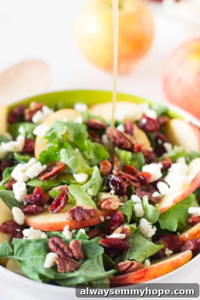17 Smart Meal Prep Salads to Kickstart Your New Year 14 A delicious apple pecan salad featuring savory vegan 'feta' cheese, with a sweet and tangy maple apple dressing being elegantly drizzled over it, enhancing its fresh appeal and vibrant flavors.