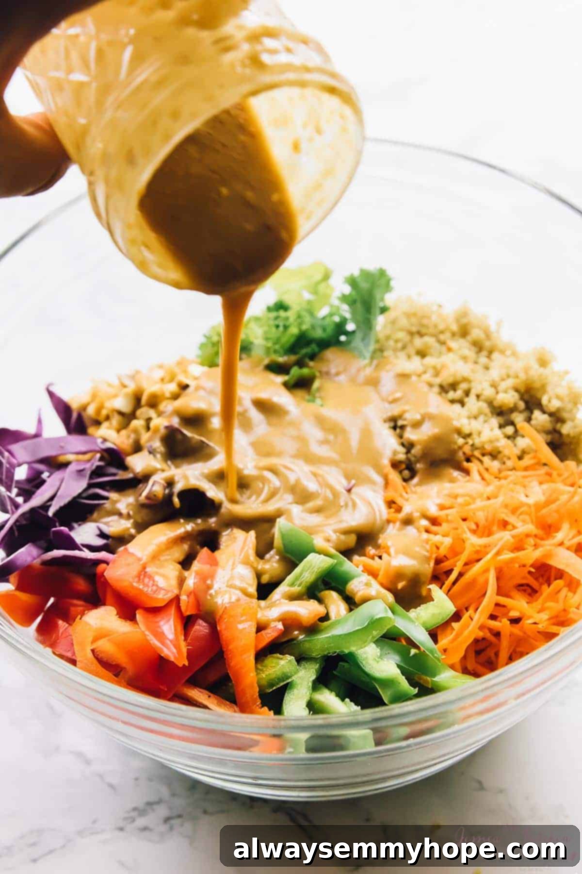 Kickstart Your New Year Health: 30 Must-Have Kitchen Staples 4 Cashew sauce being poured onto thai quinoa salad, in a glass bowl.