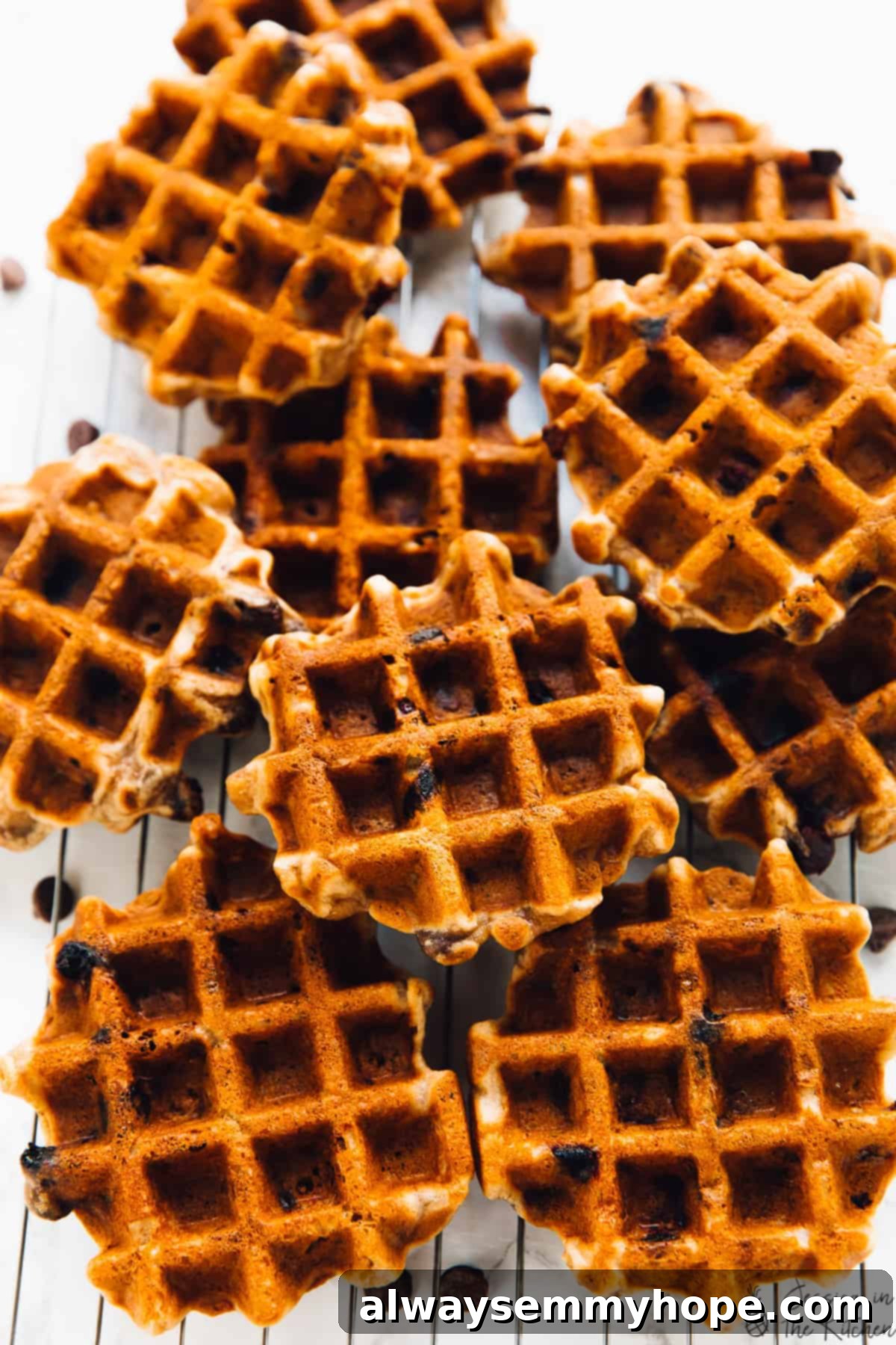 A freshly made batch of golden banana bread waffles cooling on a wire rack, showcasing their perfect texture and readiness for topping.