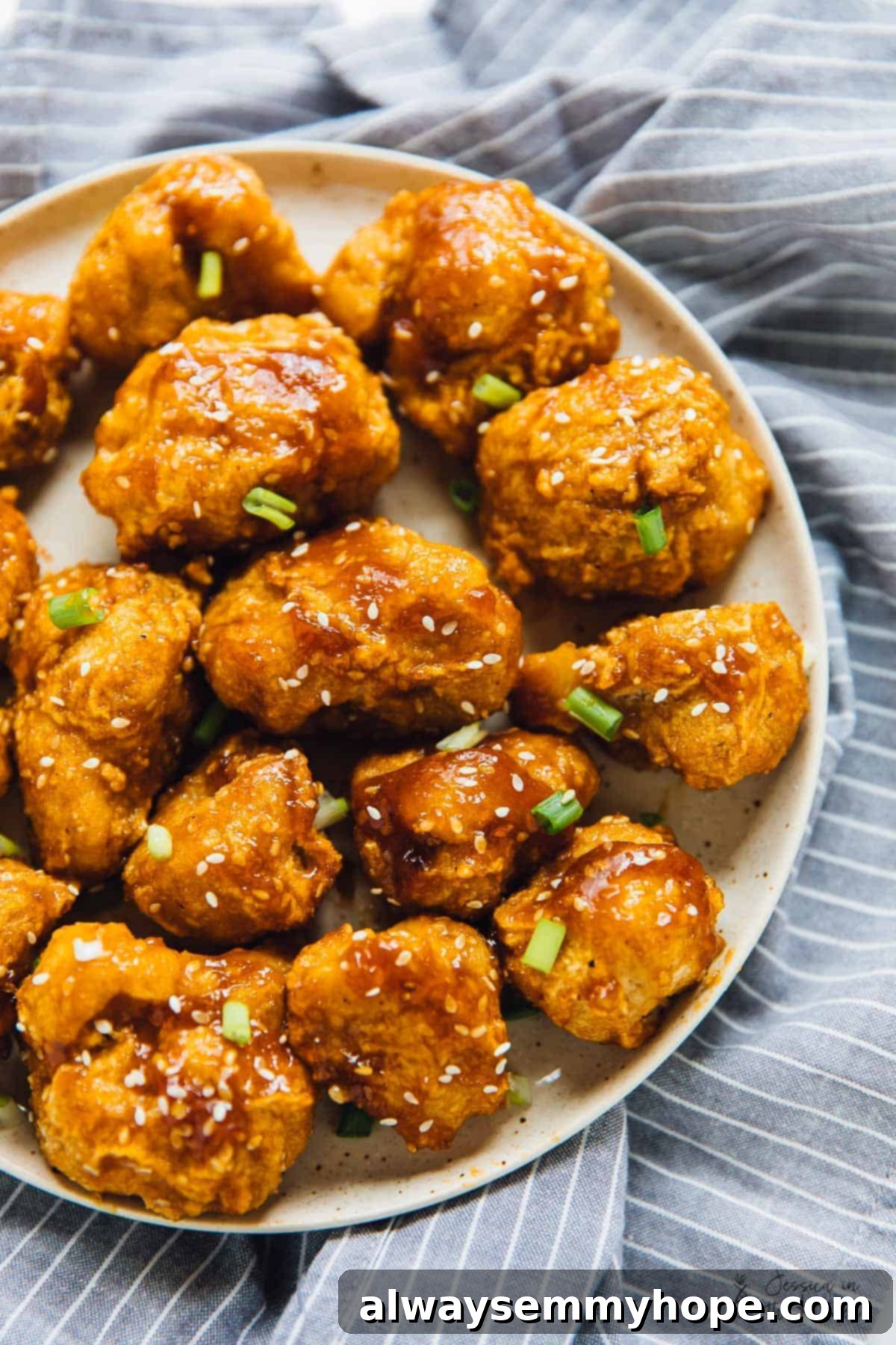 10 Quick & Easy Vegan Fakeaway Recipes 10 Top down shot of sweet and sticky orange cauliflower bites on a plate for a roundup on Vegan Takeout Recipes.