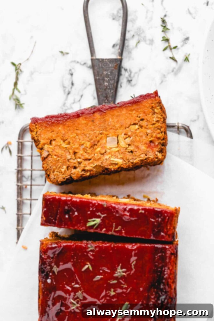 A perfectly sliced vegan meatloaf, featuring a rich glaze and a dense, satisfying texture, ready to be served as a comforting meal.