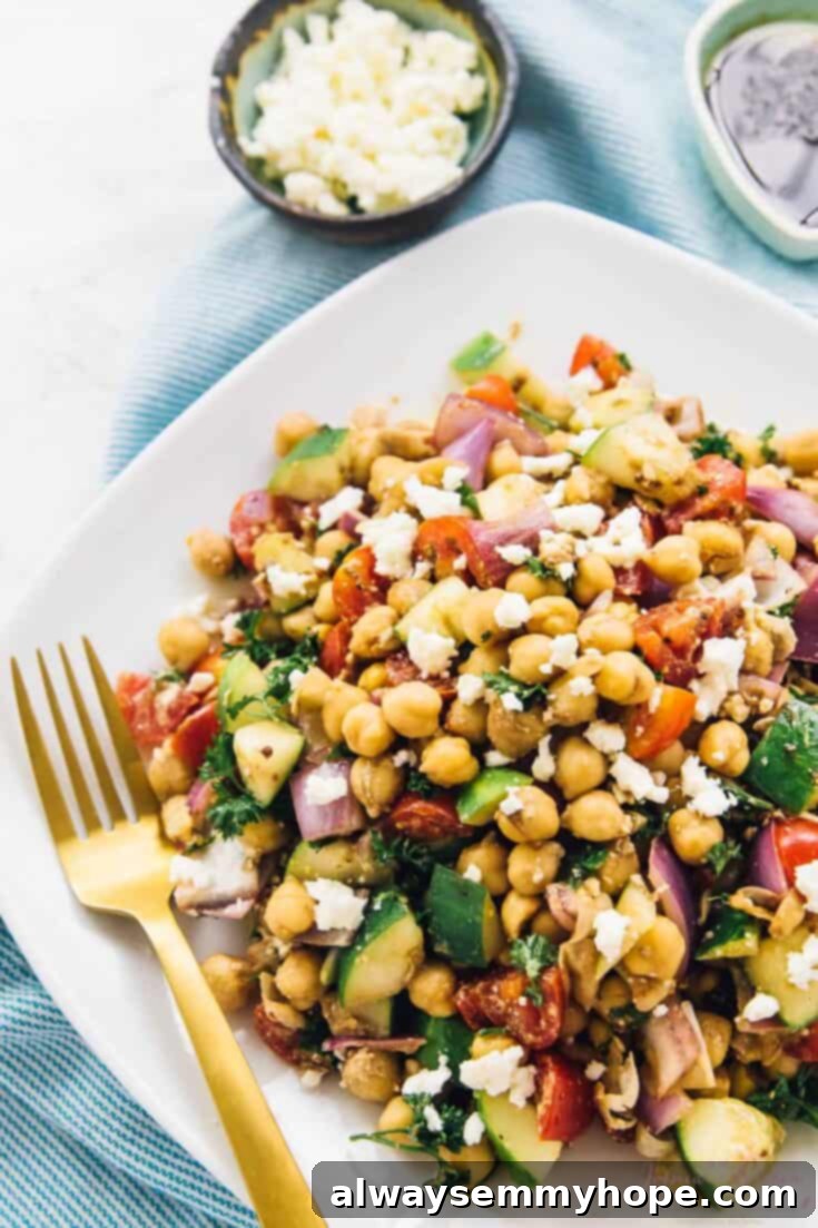 A fresh and colorful 15-minute Mediterranean Chickpea Salad, featuring cherry tomatoes, cucumbers, red onion, and fresh herbs in a light dressing.