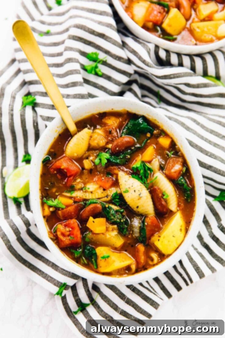 A steaming bowl of hearty minestrone soup, richly packed with fresh vegetables, pasta, and beans, promising warmth and comfort.