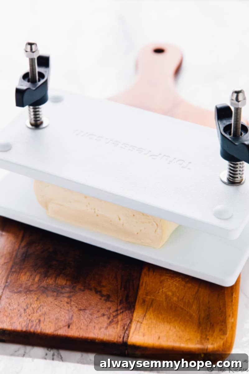 Essential Tofu Press for Best Results A tofu press on a wooden board.