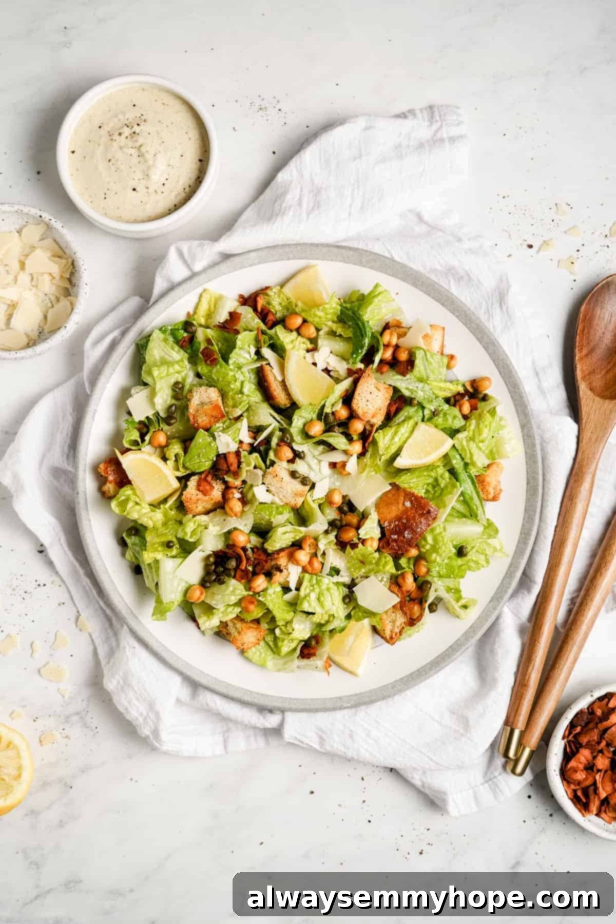 Vegan Caesar salad is perfect as a quick side dish or a light dinner! It’s made with a tangy dressing, crunchy croutons, and crisp lettuce. A close-up of a generously portioned vegan Caesar salad on a white plate, adorned with golden croutons and savory coconut bacon, highlighting its rich textures.