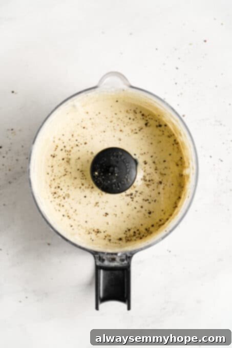 Vegan Caesar salad is perfect as a quick side dish or a light dinner! It’s made with a tangy dressing, crunchy croutons, and crisp lettuce. Close-up of freshly blended, creamy vegan Caesar salad dressing in a blender carafe, indicating a smooth and rich texture.