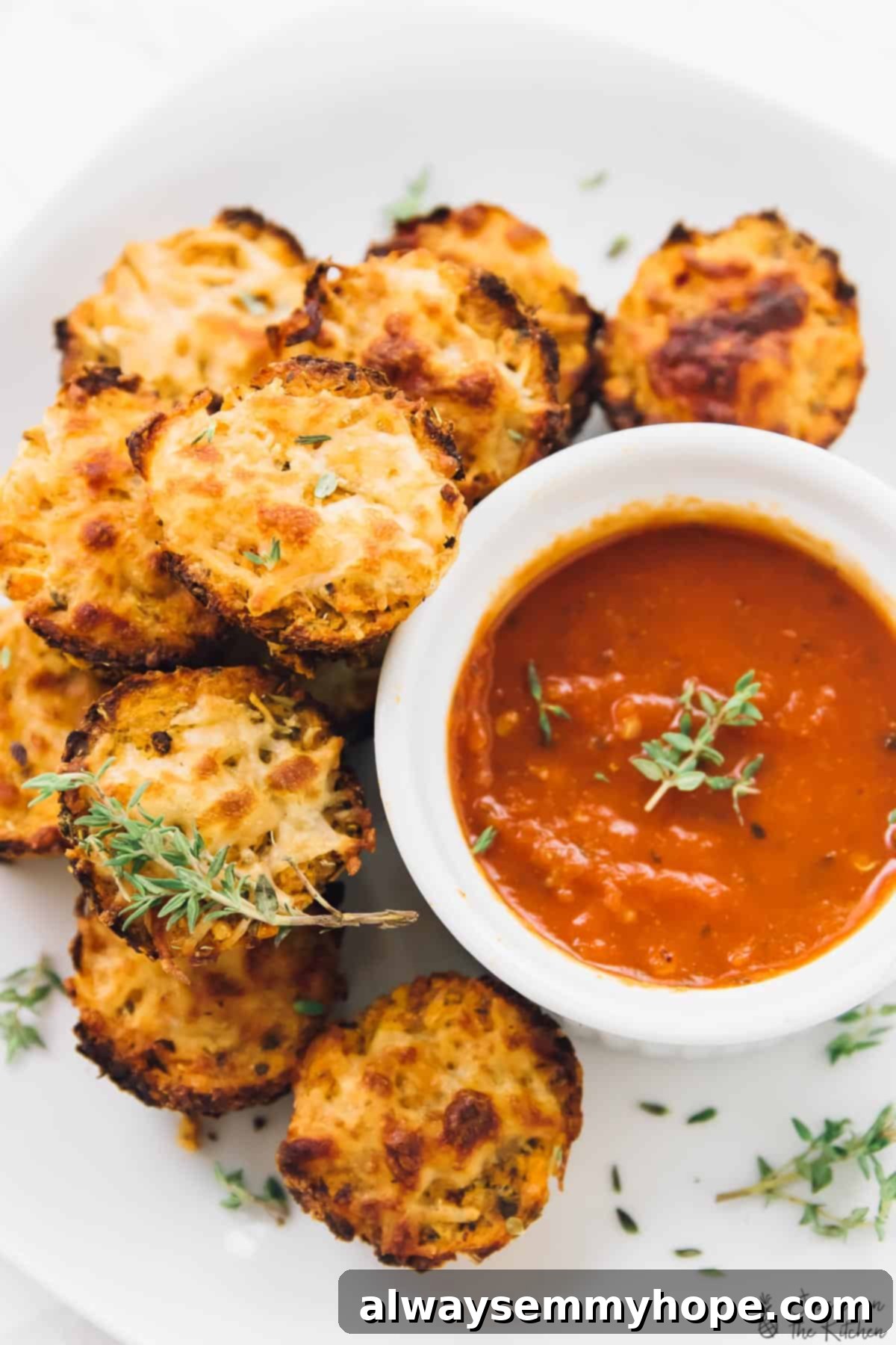 Cauliflower pizza bites next to a bowl of tomato sauce.