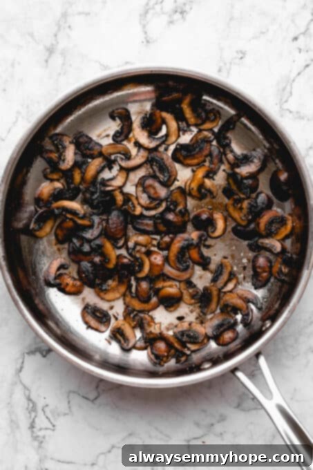 Sautéed mushroom slices in a pan.