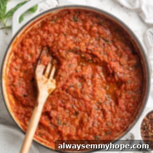 Overhead view of arrabbiata sauce in skillet with wooden spoon