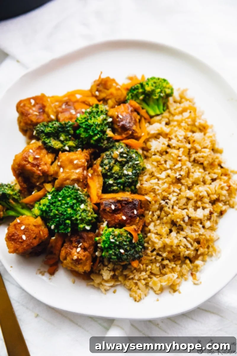 Zesty Peanut Ginger Tempeh Stir Fry 2 Top down view of tempeh stir fry on a white plate.