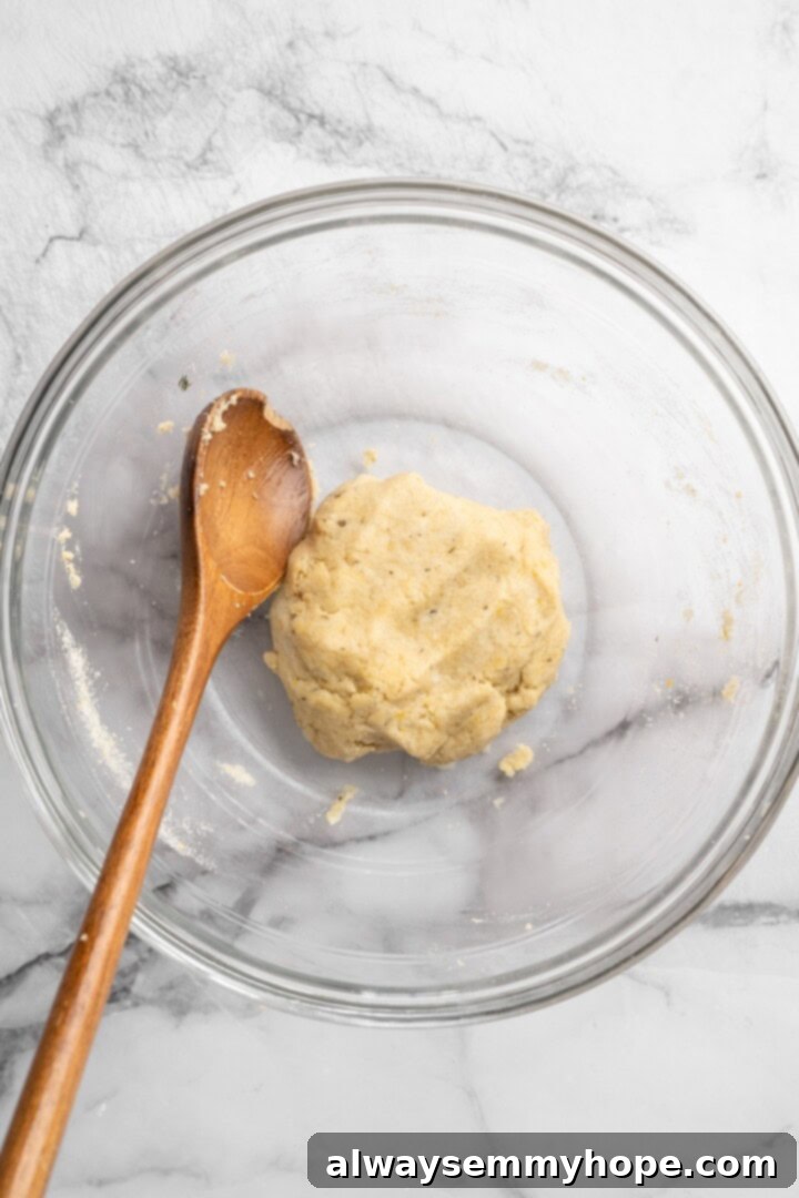 A ball of dough for almond flour pizza crust formed in a mixing bowl, ready for shaping.