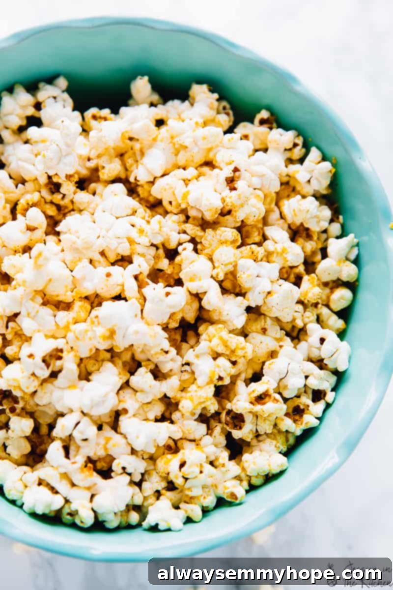 A large bowl of freshly popped, golden stovetop popcorn, ready to be seasoned.