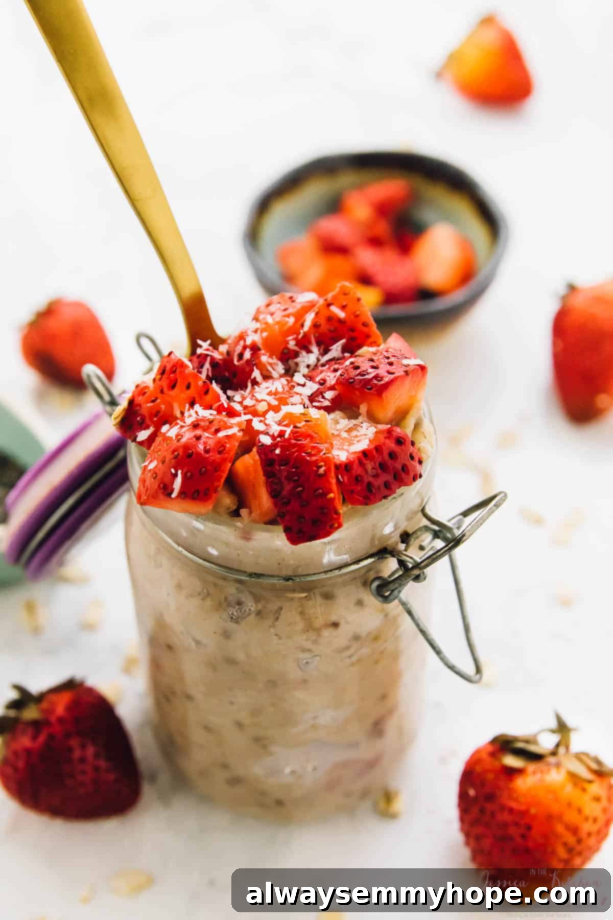 Strawberry coconut overnight oats in a glass jar, beautifully garnished with fresh strawberries.