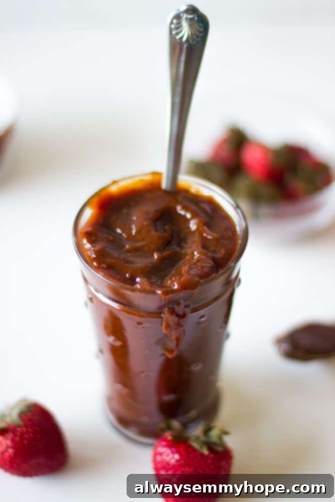 A glass full of roasted strawberry barbecue sauce, ready to be enjoyed with grilled dishes.