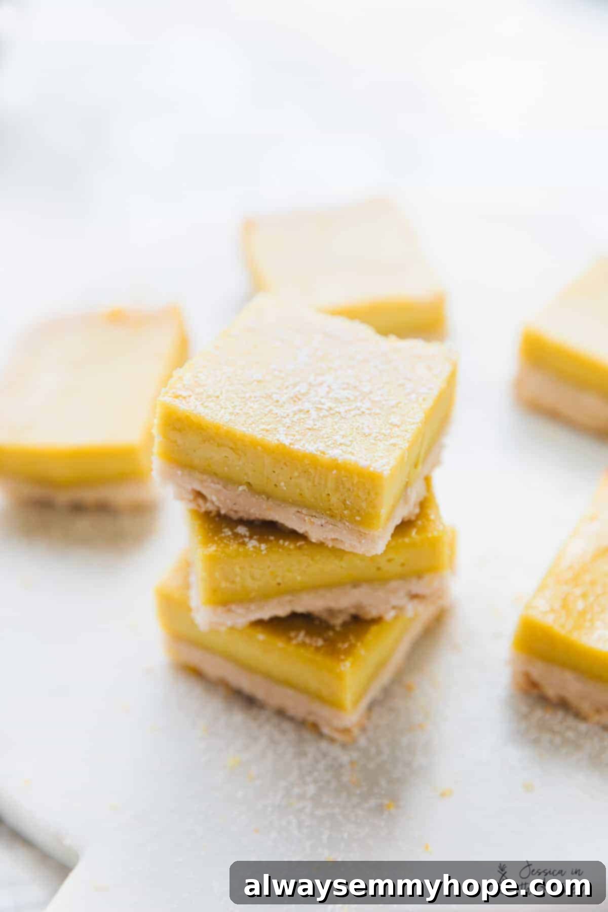 A stack of vegan lemon bars, surrounded by more bars. 