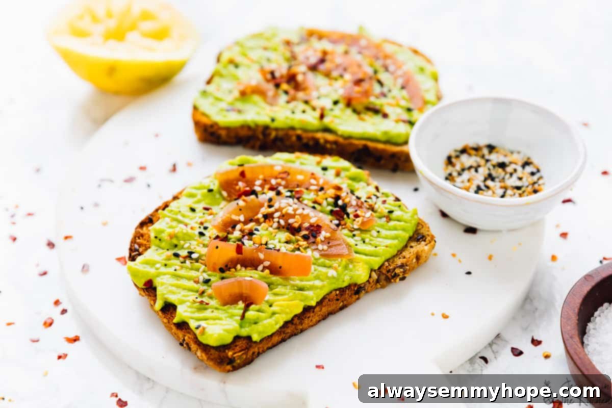 Close-up side view of a perfectly stacked avocado toast slice, highlighting the creamy avocado and crispy toast layers
