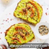Top down shot of avocado toast on a white marble board.