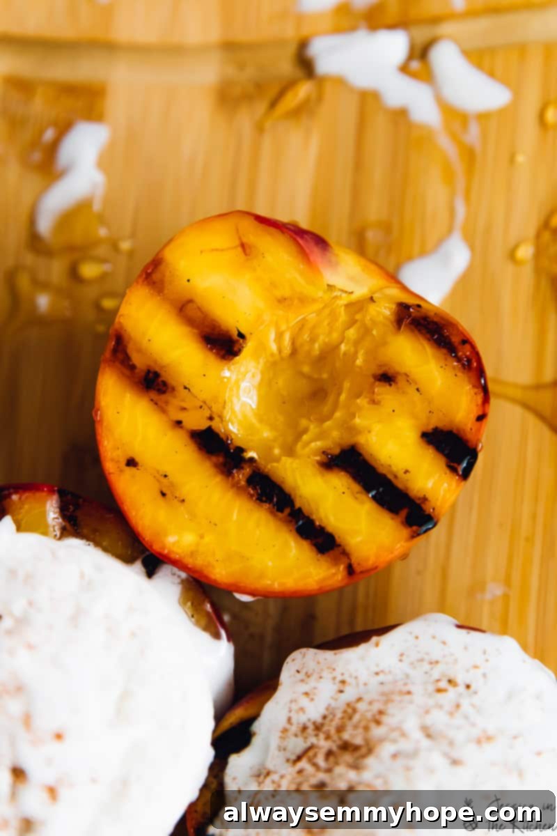 Juicy grilled peaches are sweet, smoky, and the perfect summer treat topped with vegan coconut ice cream! It takes minutes on a hot grill. Overhead shot of grilled peaches, some topped with ice cream.