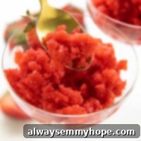 A spoonful of strawberry granita, highlighting its refreshing icy texture.