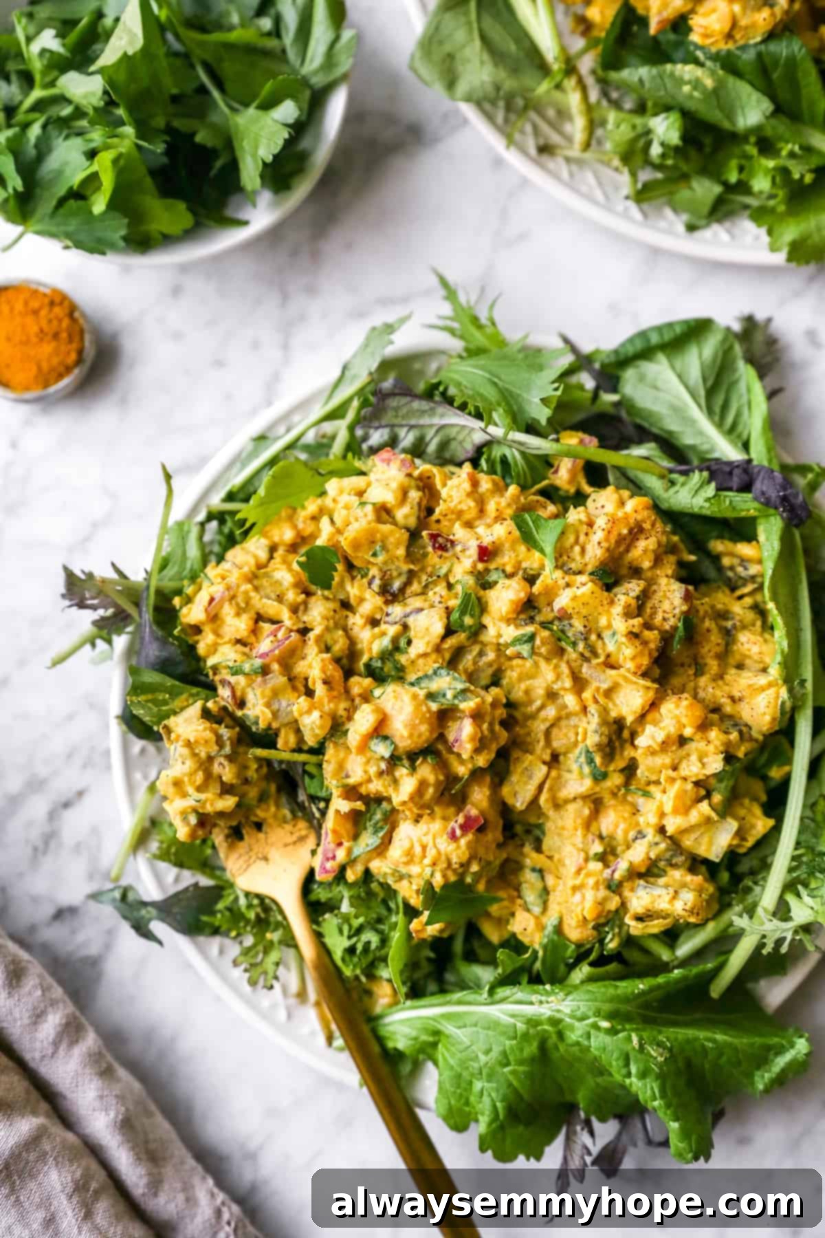 curried chickpea salad elegantly presented on a plate, with other dining elements blurred in the background, highlighting its vibrant texture