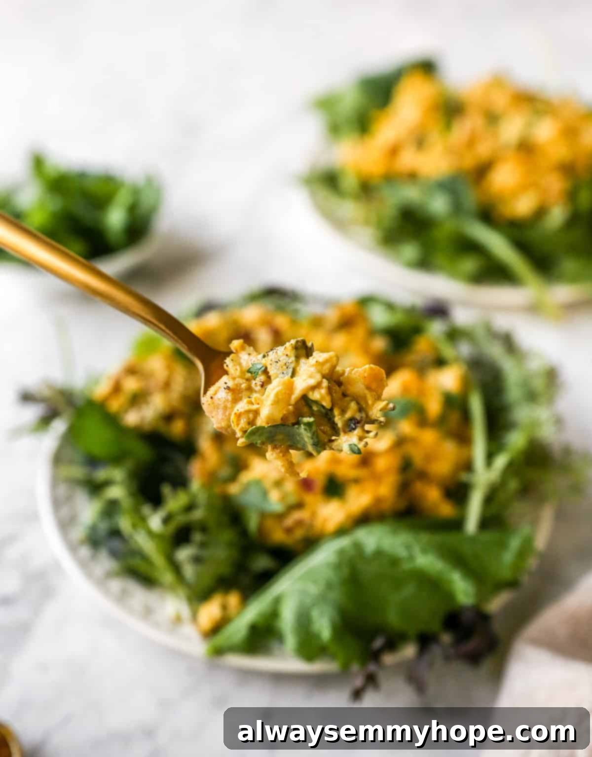 close up shot of a delicious bite of curried chickpea salad on a fork, ready to be enjoyed