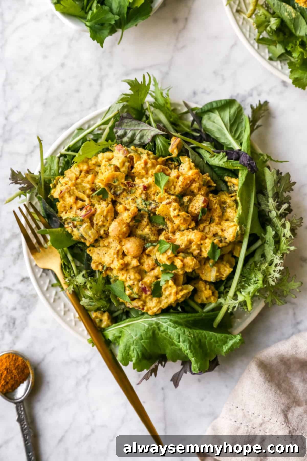 curried chickpea salad generously served on a bed of fresh greens, ready to eat