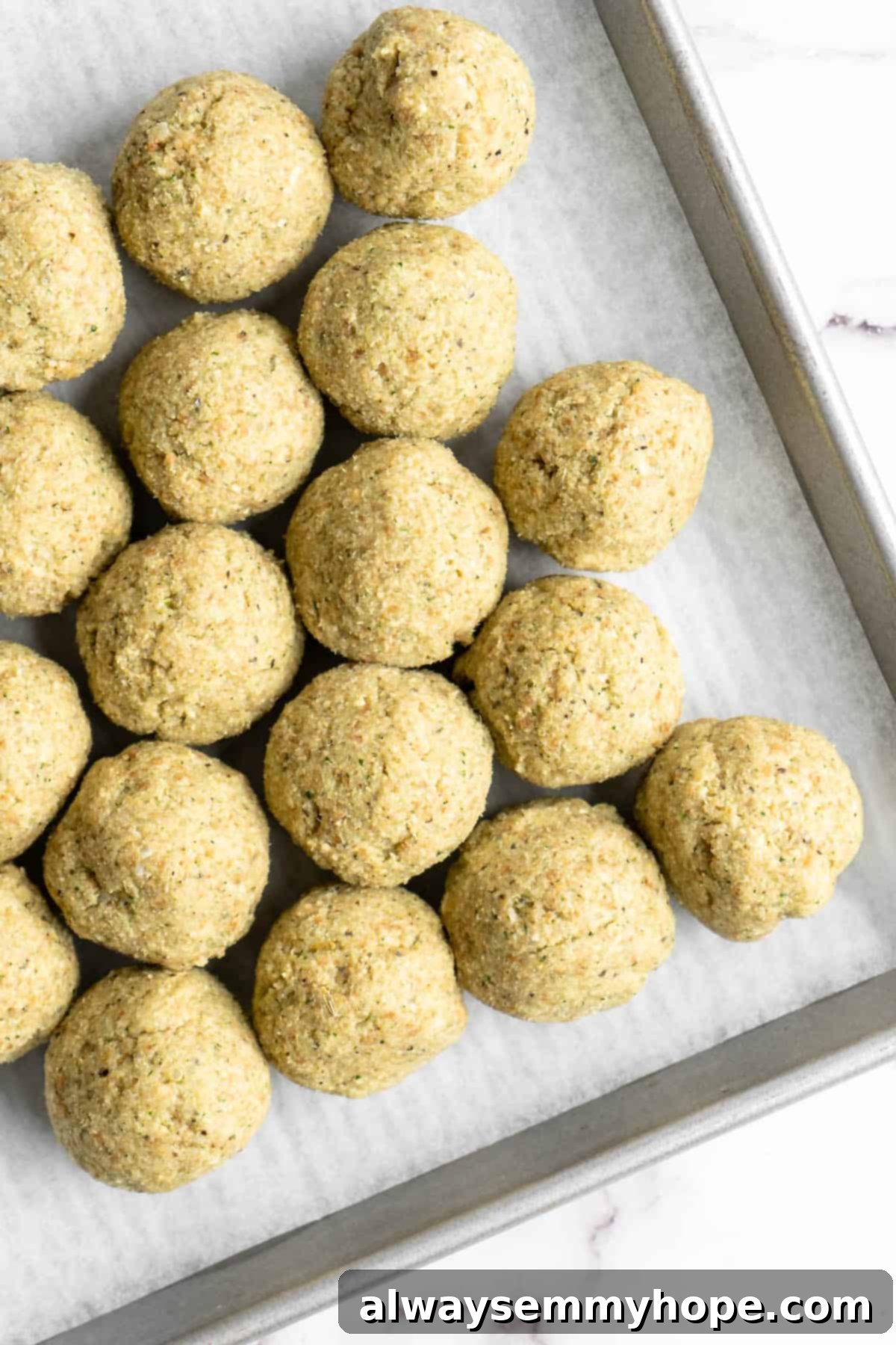 Plant-Powered Spaghetti & Meatballs 9 Uncooked vegan meatballs on parchment lined sheet pan