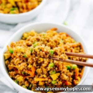 Chopsticks picking up quinoa fried rice from white bowl