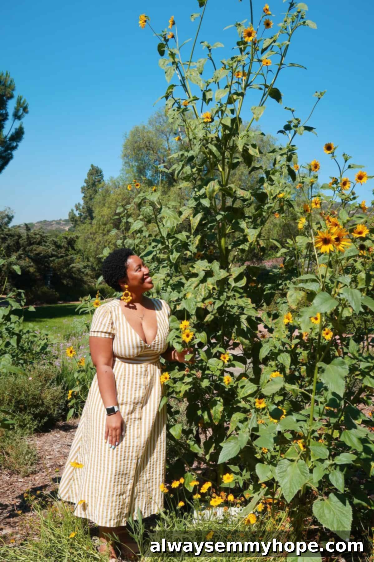 Jessica smiling at a bush at Rancho La Puerta, a luxury wellness retreat in Tecate, Mexico.