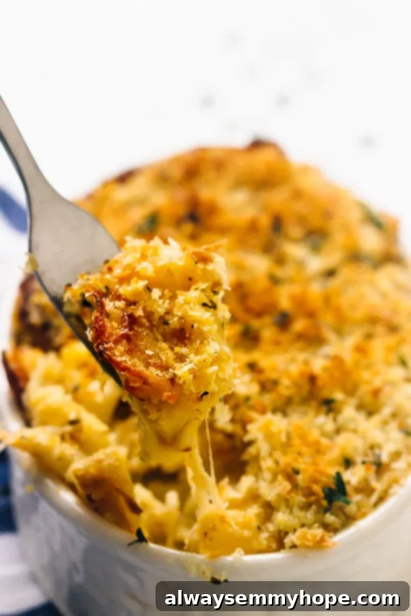 15 Irresistible Vegan Pumpkin Recipes for Fall 12 A fork pulling out some gooey vegan baked pumpkin mac and cheese from a dish.