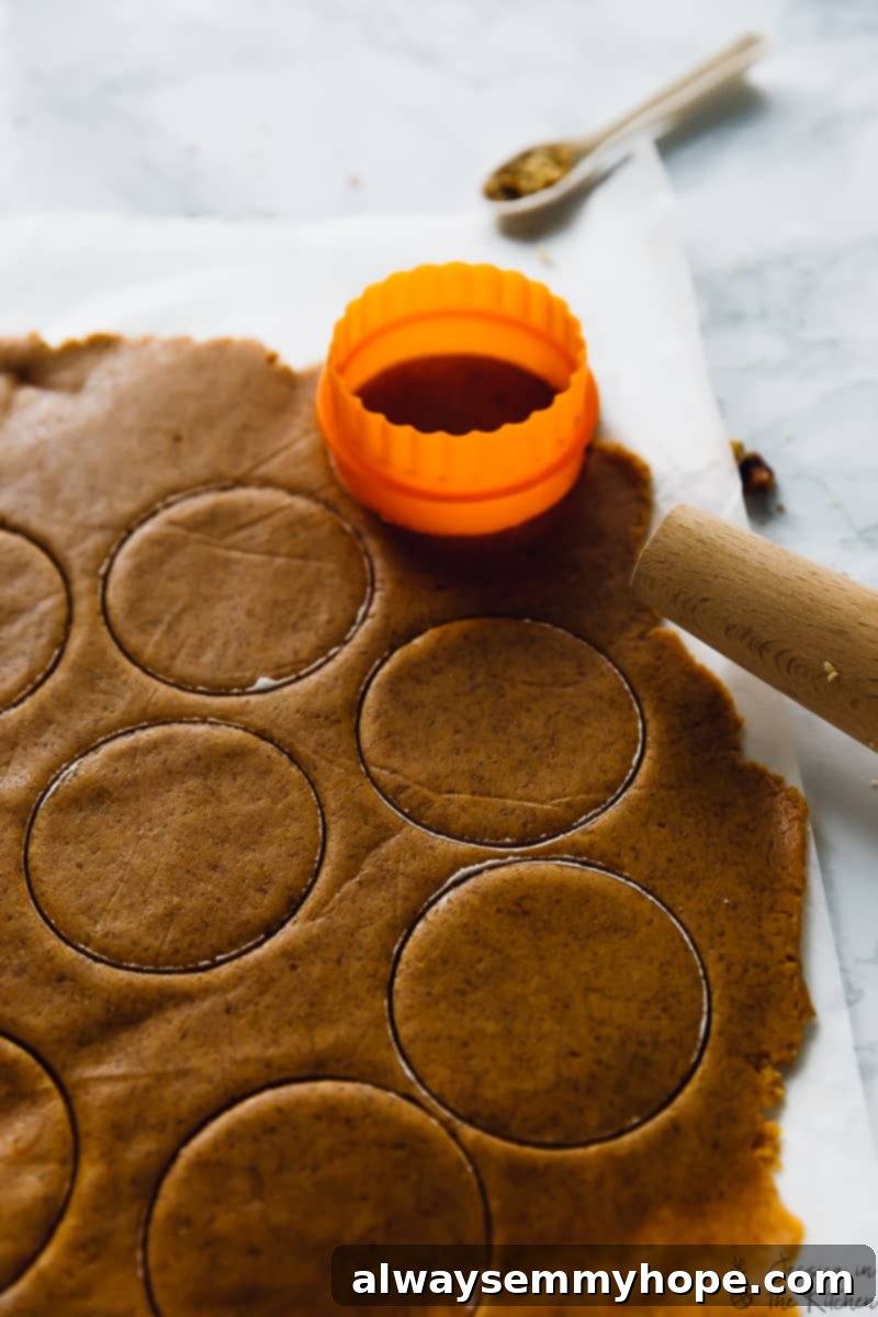 Cutting cookie dough into circles from a sheet of dough. 