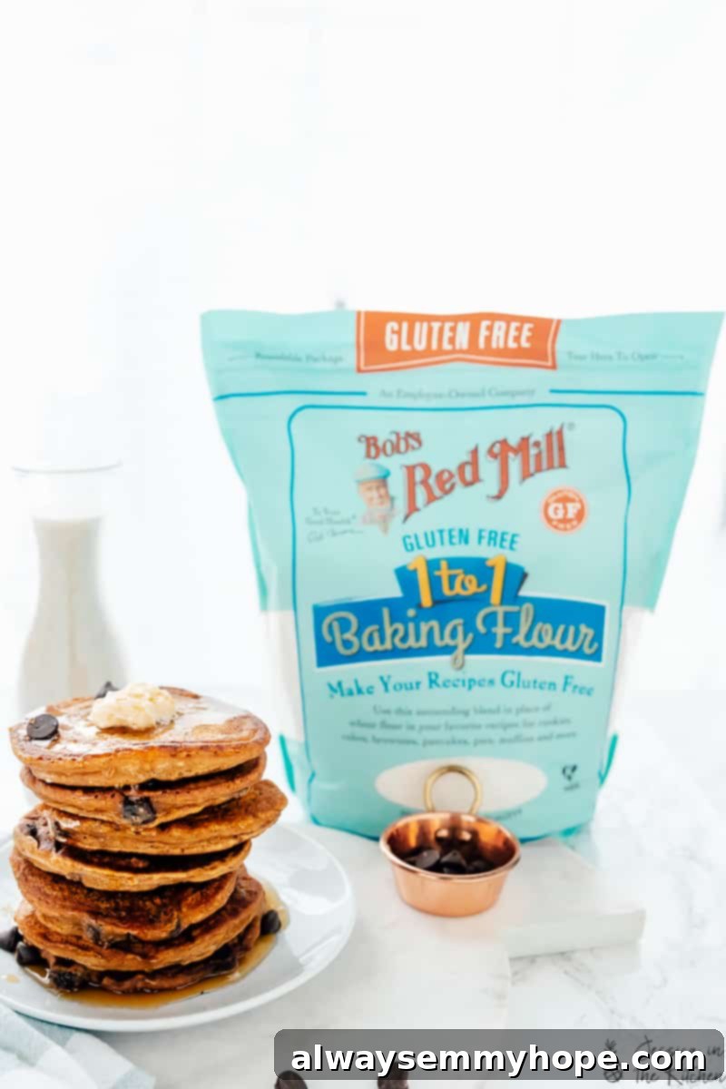 These pumpkin chocolate chip pancakes are prepped in 10 minutes! Made with pumpkin pie spice and pumpkin puree, they're perfect for fall. A stack of chocolate chip pancakes next to a bag of baking flour, ready for cooking.