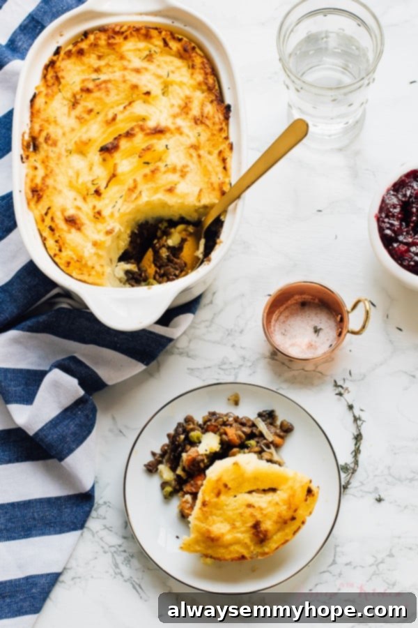 A generous serving of vegan shepherd's pie on a plate, with a baking dish in the background.