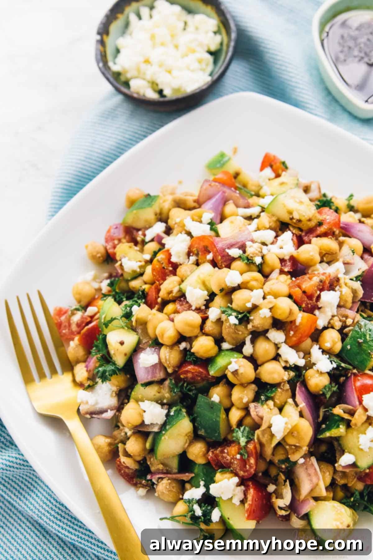 Mediterranean chickpea salad artfully arranged next to a bowl of vegan cheese.