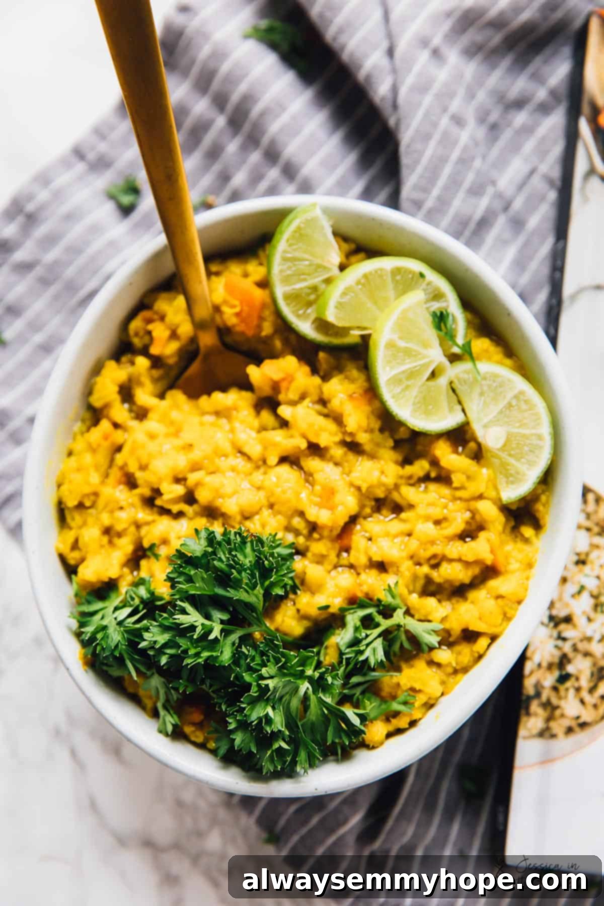 Gentle Morning Kitchari served in a bowl, garnished with fresh lime wedges.