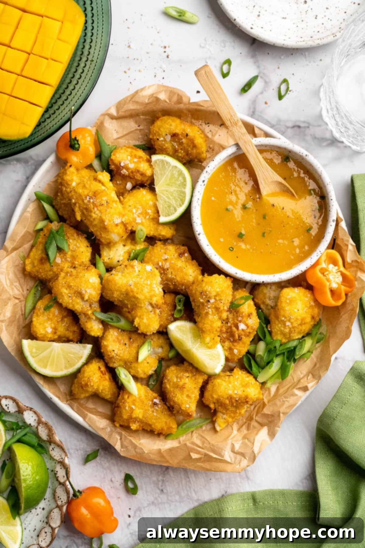 If you love your heat with a side of sweet, these mango habanero cauliflower wings will blow your tastebuds away. An easy crowd-pleaser! Overhead view of large platter of mango habanero cauliflower wings with bowl of sauce
