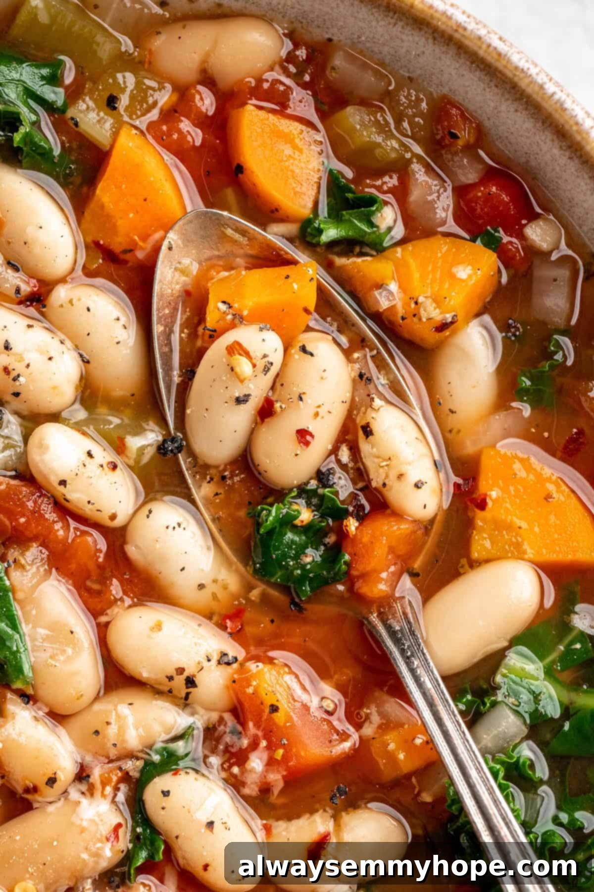 Close-up of a spoonful of white bean and kale soup, highlighting the texture