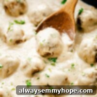 Vegan Swedish meatballs in skillet with wooden spoon, garnished with parsley