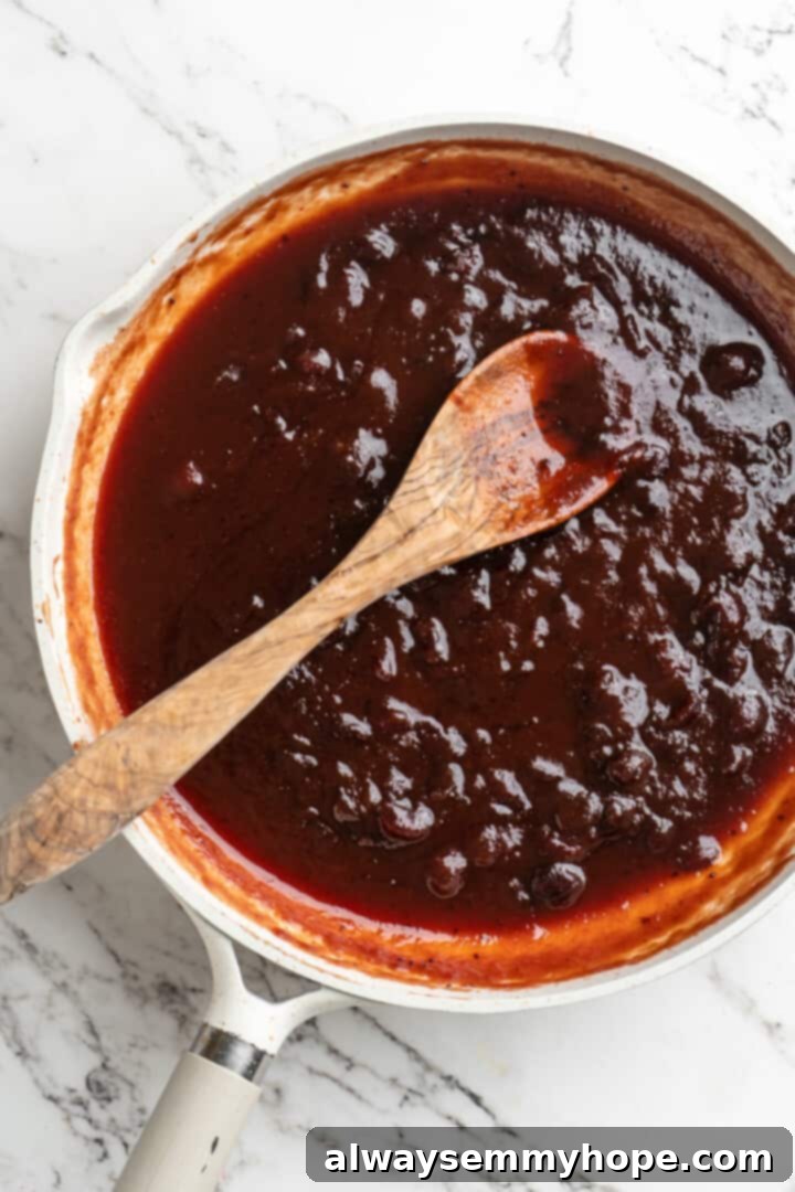Overhead view of cranberry sauce in skillet with wooden spoon