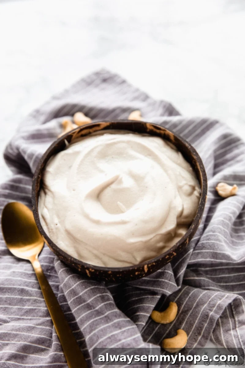 Kaju Kreması Tarifi: Süt Ürünü İçermeyen Enfes Vegan Alternatif 5 A bowl of cashew cream on a striped cloth, showcasing its smooth, versatile texture.