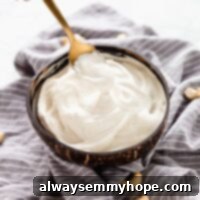 Kaju Kreması Tarifi: Süt Ürünü İçermeyen Enfes Vegan Alternatif 6 A spoon dipping into a bowl of creamy homemade cashew cream, ready to be used as a versatile vegan substitute.