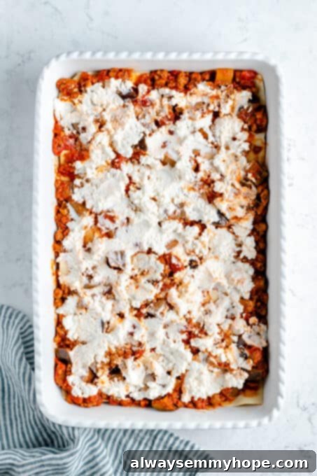 Vegan ricotta cheese on top of a layer of sauce.