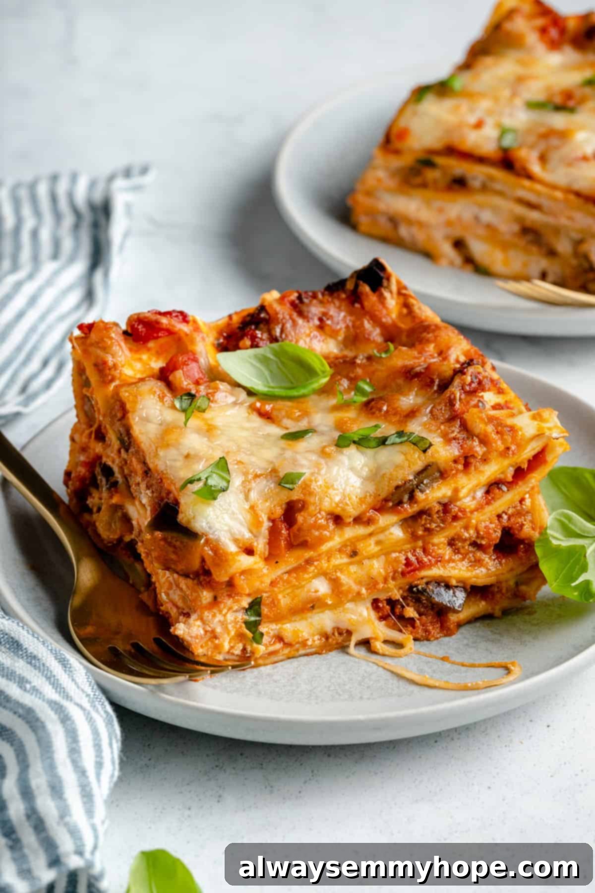 A plate of cheesy lasagna with basil.