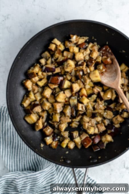 Eggplant cubes sautéing in a pan.